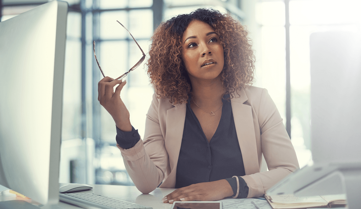 Black lady at desk with laptop looking up